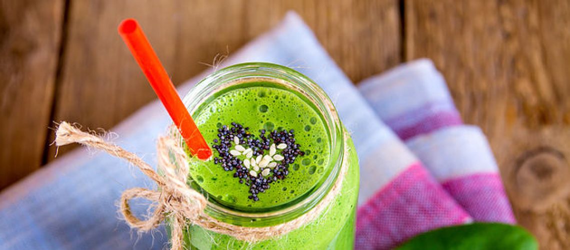 Green vegetable and herbs smoothie with heart of poppy and sesame seeds. Love for a healthy raw food concept.